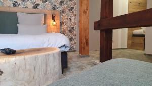 a bedroom with two beds and a wooden log table at Hotel Le Filou in Hille