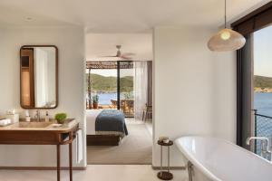 
a bath room with a tub and a window at Six Senses Ibiza in Portinatx
