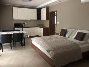 a bedroom with a bed and a table and chairs at Second Home Apartments Miskolctapolca in Miskolctapolca
