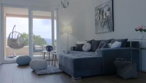 a living room with a blue couch and a large window at Apartments King and Queen in Povile