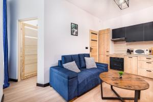 a living room with a blue couch and a table at Bm apartamenty Wały Chrobrego Radogoska12A in Szczecin