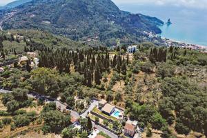 an aerial view of a house on a hill next to the water at Villa Barocco Corfu in Kamára