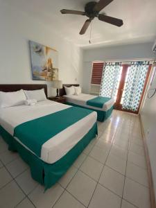1 dormitorio con 2 camas y ventilador de techo en Ocean Palms en Ocho Rios