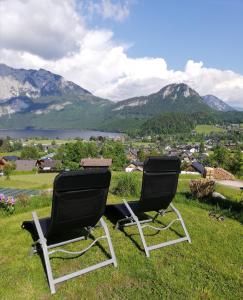 two chairs sitting on top of a field with mountains at Haus Horvath Bett und Brot in Altaussee