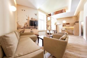 a living room with a couch and chairs and a table at Yourplace Top Apartments in Krakow