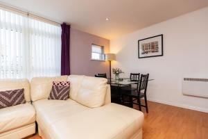 a living room with a white couch and a table at Oakstays Stylish Quayside Gem in Gateshead