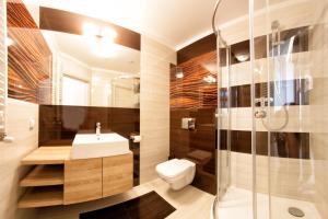 a bathroom with a shower and a toilet and a sink at Yourplace Top Apartments in Krakow
