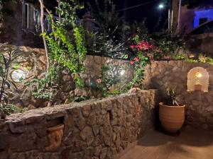 a stone wall with potted plants on it at Leonidas Apartments in Kamari