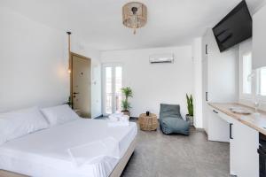 ein weißes Schlafzimmer mit einem weißen Bett und einem Schreibtisch in der Unterkunft Theogonia in Ermoupoli