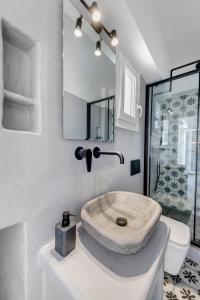 a white bathroom with a sink and a toilet at Theogonia in Ermoupoli