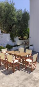 a wooden table and four chairs and a wooden table and benches at Skalopati Studios & Villa in Panormos Skopelos