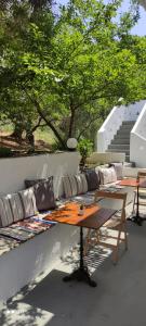a patio with a table and couches and trees at Skalopati Studios & Villa in Panormos Skopelos