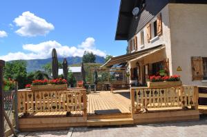 a wooden deck in front of a building with flowers at La Foret De Maronne in La Garde