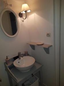 a bathroom with a sink and a mirror at Au Petit Nid de Sanguinet in Sanguinet