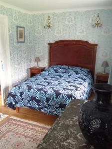 a bedroom with a bed and a vase on a table at Chambre E André Le Domaine Des Jardins De Bracquetuit in Bracquetuit
