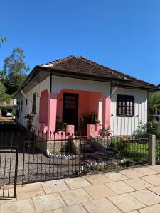 a small house with a fence in front of it at CASA TREIN - há 20 minutos do centro de Gramado in Três Coroas