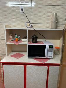 a microwave sitting on top of a table at CASA TREIN - há 20 minutos do centro de Gramado in Três Coroas