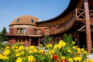 a building with a flower garden in front of it at Vila Sraige in Palanga