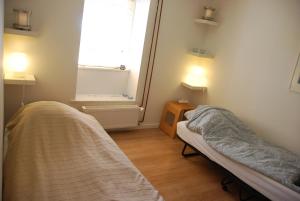 Habitación pequeña con 2 camas y ventana en Quistgaarden Bed & Breakfast, en Spjellerup