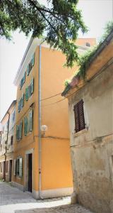 an orange building is next to a street at Casa Arancin in Poreč