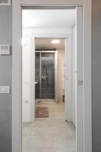 a bathroom with a glass door leading to a shower at Appartamento Campagnola Mansardato in Riva del Garda