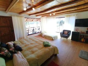 1 dormitorio con cama, sofá y TV en Villa Aventura Lodge, en Cajamarca