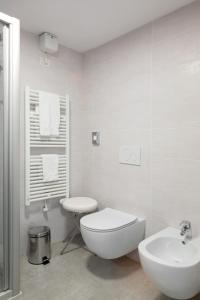 a white bathroom with a toilet and a sink at Appartamento Campagnola Mansardato in Riva del Garda