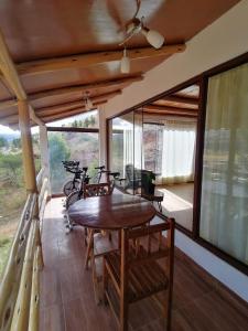 une terrasse couverte avec une table et des chaises en bois. dans l'établissement Villa Aventura Lodge, à Cajamarca