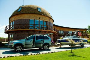 a car parked in front of a house with a boat at Vila Sraige in Palanga