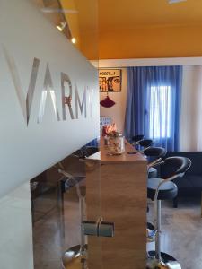 une salle de conférence avec des chaises et un grand panneau mural dans l'établissement Varmy, à Ierápetra