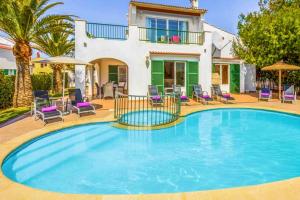 a swimming pool in front of a house at Villa SOFIA in Cala en Forcat