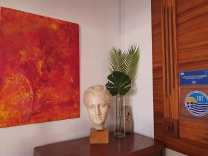 a statue of a head on a table next to a painting at Varmy in Ierápetra