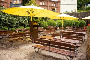 un grupo de mesas y sillas con sombrillas amarillas en Hotelpark Stadtbrauerei Arnstadt, en Arnstadt