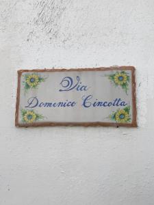 a sign on a wall with flowers on it at A' Riggiola in Stromboli