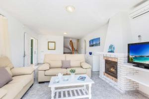 a living room with a couch and a fireplace at Villa SOFIA in Cala en Forcat
