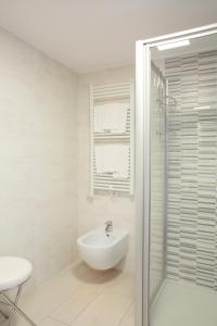 a white bathroom with a sink and a shower at Appartamento Campagnola Mansardato con soppalco in Riva del Garda