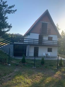 ein großes weißes Haus mit einer Veranda und einer Terrasse in der Unterkunft NG Apartmani Tornik Zlatibor in Zlatibor