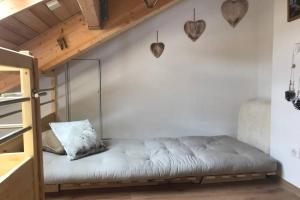 a futon bed in a room with a wooden ceiling at Magnifique appartement à la Joue du Loup in Le Dévoluy +27 photos