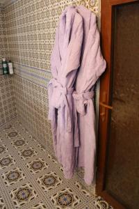 a purple towel hanging on the wall of a bathroom at Hotel Gumbaz in Samarkand