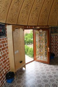 een open deur in een kamer met een bakstenen muur bij Hotel Gumbaz in Samarkand