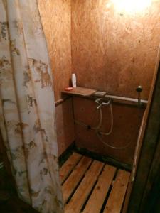 a small bathroom with a shower with a wooden floor at Kadariku Tourism Farm in Sakla