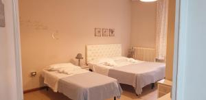 a bedroom with two beds with white sheets at hotel lisà in Viareggio