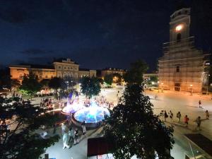 a group of people walking around a plaza at night at Prenociste Nikolas Grand in Smederevo