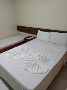 a large white bed with two pillows on it at Hotel Sol Bahia in Porto Seguro