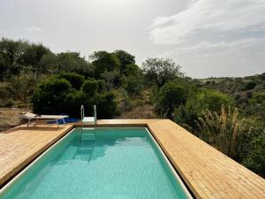 einen Pool mit einer Terrasse, einem Tisch und einem Stuhl in der Unterkunft Villa Ananda homestay & yoga retreat in Palazzolo Acreide