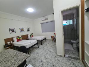 a room with a bathroom with a toilet and a sink at Hotel Flor de Minas in Uberaba +60 photos