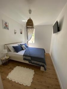 a bedroom with a bed with blue sheets and a television at Holiday house Aria di Mare in Starigrad-Paklenica
