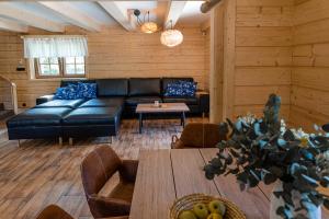 a living room with a black couch and a table at U Justina na potůčku in Velké Karlovice