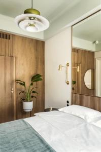 a bedroom with a large bed and a potted plant at Angelus Apartments in Krakow