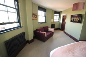 a bedroom with a couch and a chair in a room at Westow House in Crystal Palace